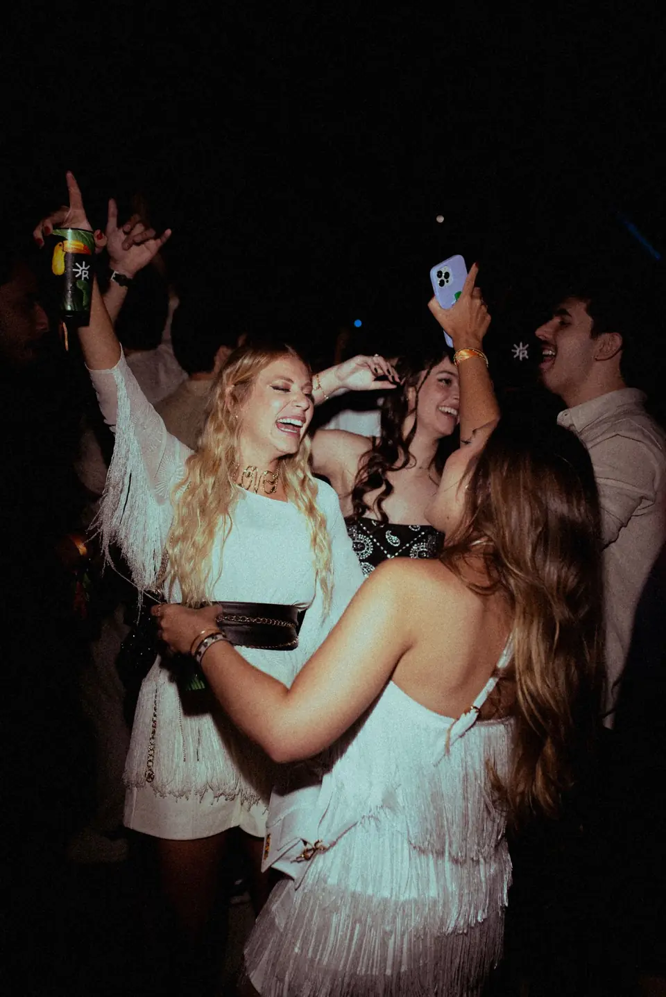 Friends dancing together in a dark room, caught by the flash