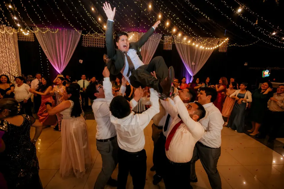 Guests lifting the groom on the dance floor