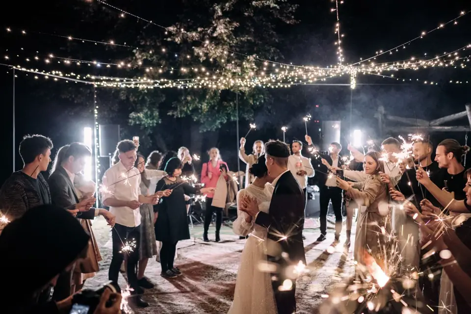 Wedding guests holding sparklers around the couple’s first dance